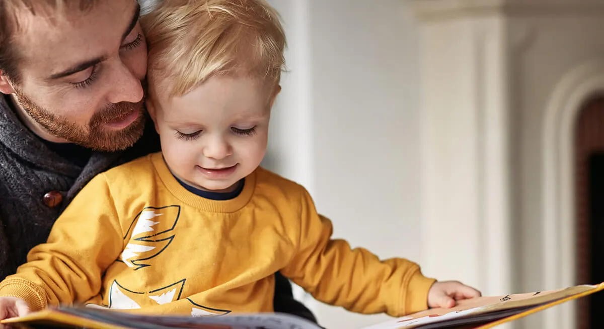 A father reading a picture book with his toddler